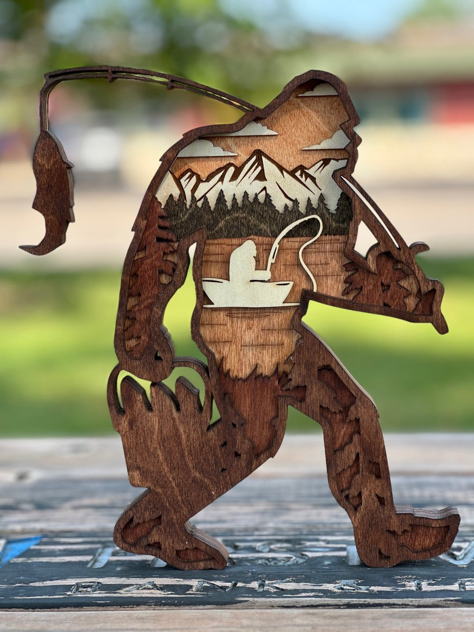 Sasquatch fishing with exceptional technique – a mysterious and whimsical laser cut wood scene by Laser Lakes