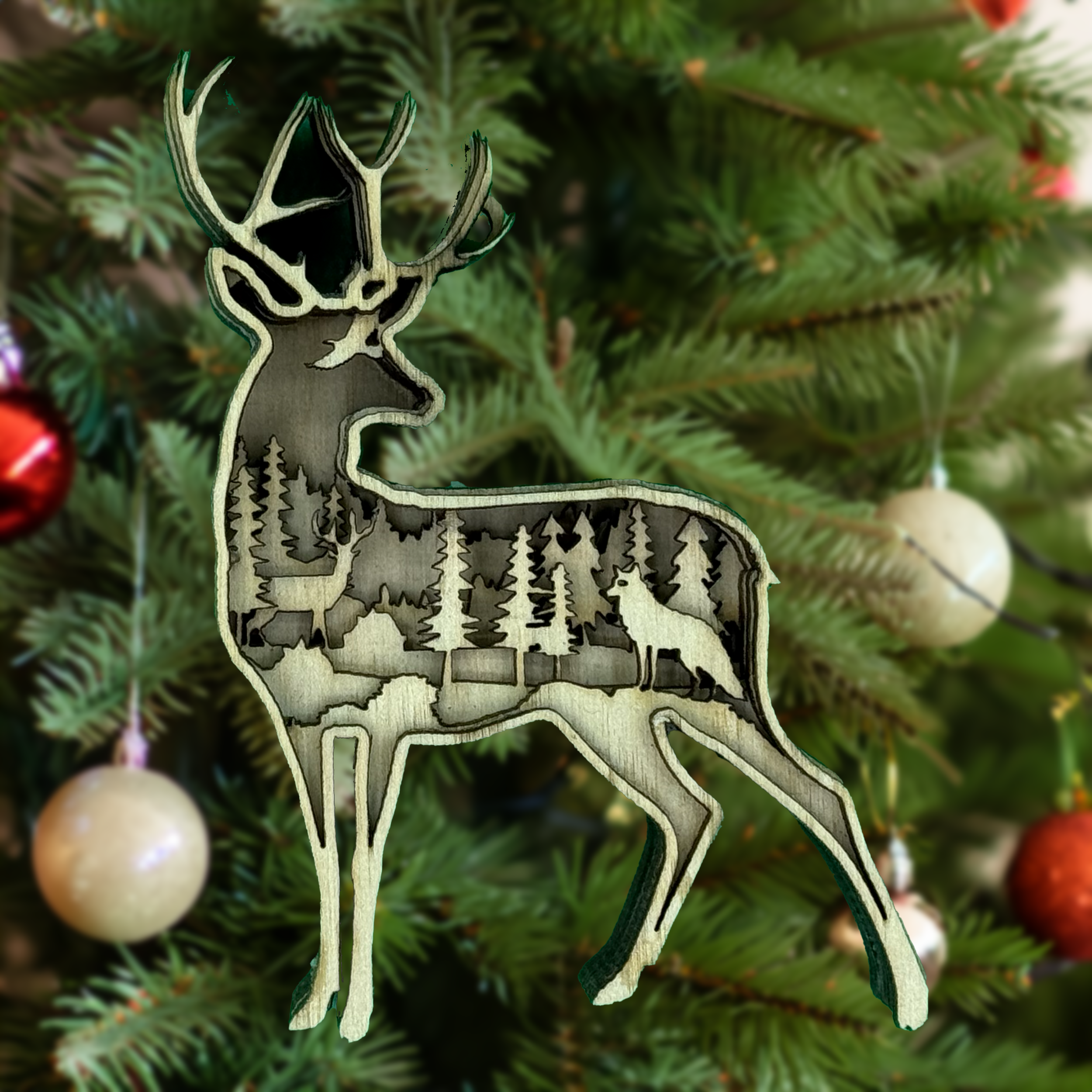 Deer in a tree forest scene – one of the most intricate laser cut ornaments by Laser Lakes