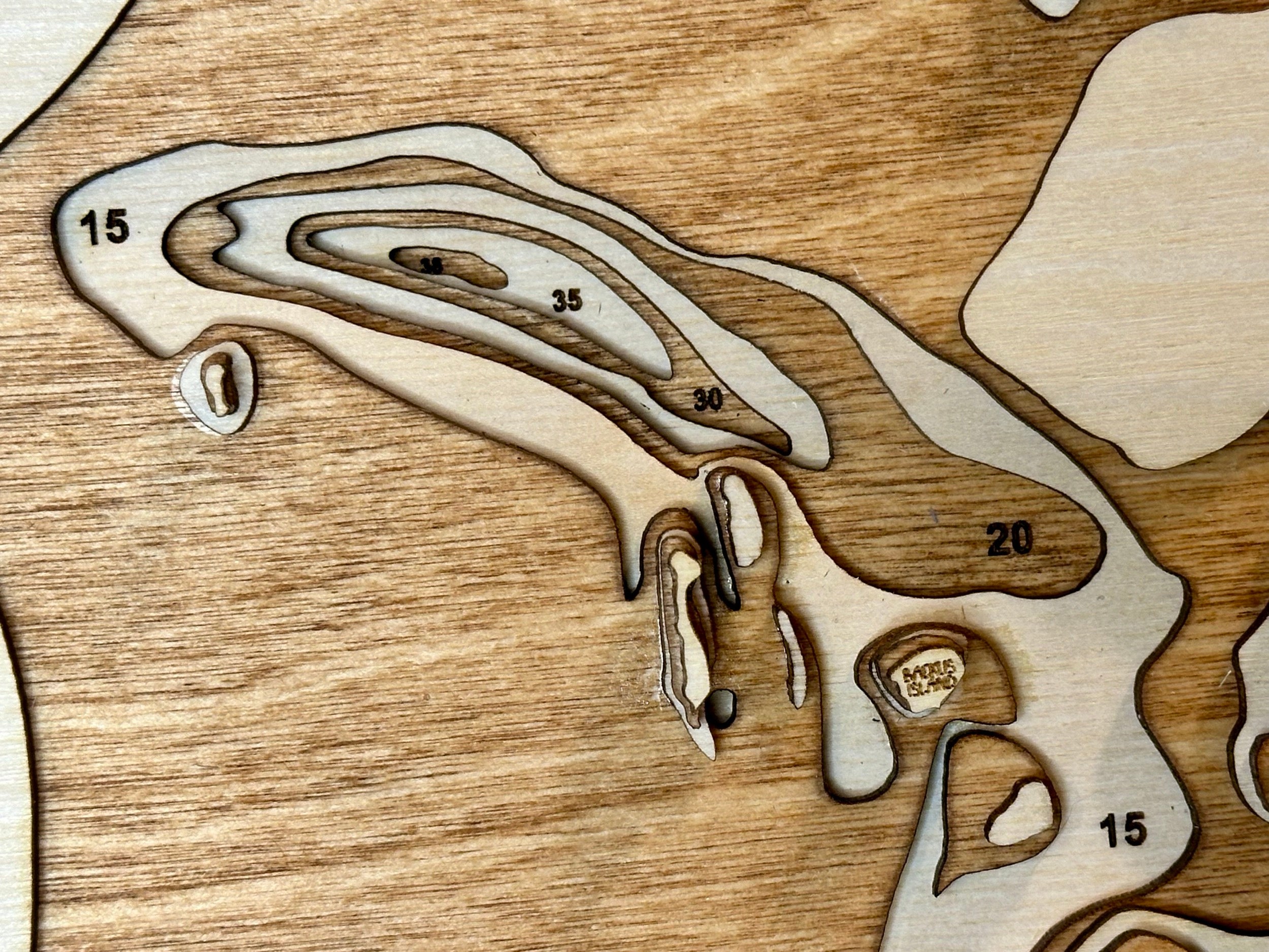 Pelican Lake topographic map showing laser-engraved depth contours in wood
